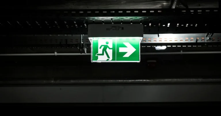 Emergency exit sign and fire equipment in a Ho Chi Minh City apartment building corridor