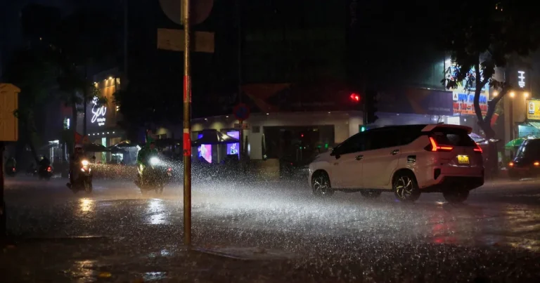 Rain-soaked HCMC street lined with apartment towers during rainy season
